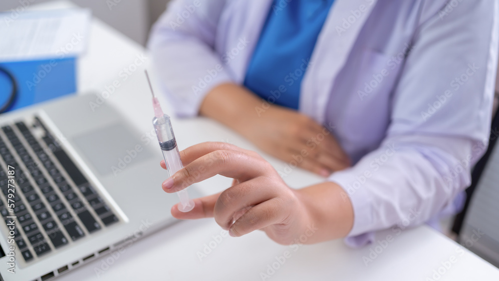 Professional medical asian woman doctor with Syringe medical injection in hand vaccine injecting health drug vaccination influenza fight against virus covid-19
