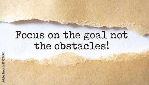 'Focus on the goal not the obstacles' written under torn paper.