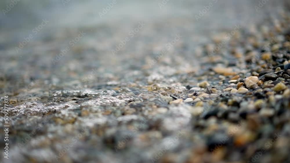 Water waves at sea shore in super slow motion 240fps closeup small rocks Water waves at sea shore in super slow motion 240fps closeup small rocks