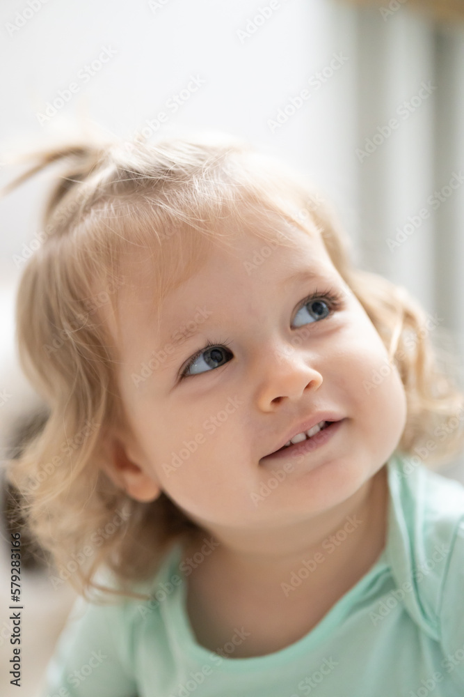 toddler girl smile and looks upward, authentic joy, bright vertical concept - obrazy, fototapety, plakaty 