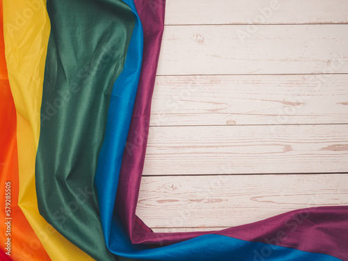 The rainbow flag or LGBTQ flag on a wooden table