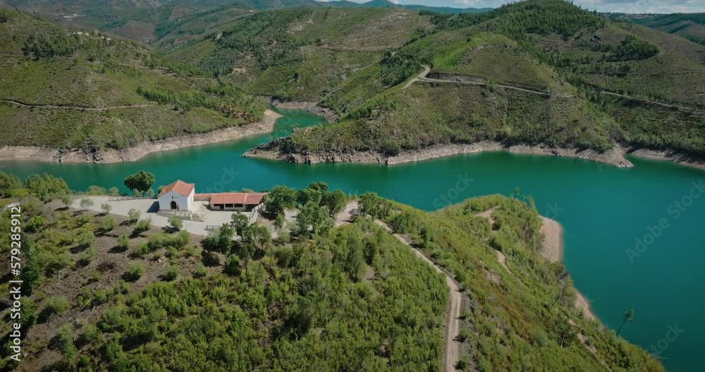Small chapel on top of a hill by a river