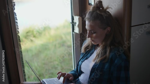Wallpaper Mural Woman freelancer working at a laptop while sitting in a car, typing text and remote work in nature, portrait inside a camper. Torontodigital.ca
