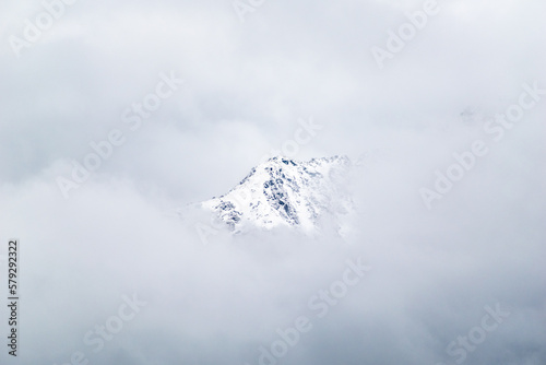 A snow capped Himalayan mountain peak surrounded by clouds in the Kumaon region of Uttarakhand.