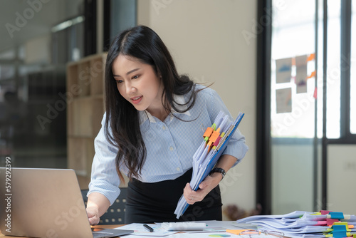 Businesswoman working with a pile of documents.