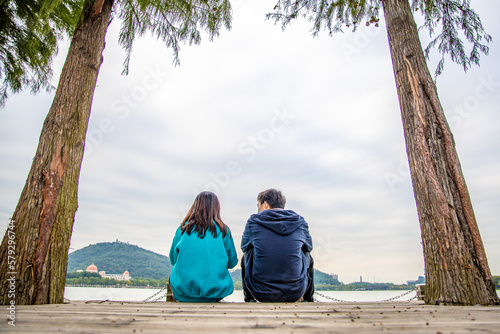 A couple chatting under a lake tree