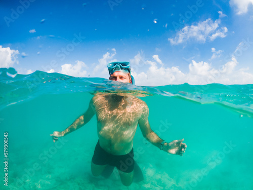 man snorkeling in crystal clear tropical sea © Melinda Nagy