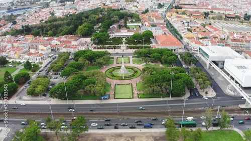 Drone shot of a parkwith sculpture and trees in the middle of a big city photo