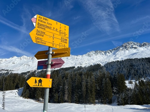 Hiking markings and orientation signs with signposts for navigating in the idyllic winter ambience above the tourist resorts of Valbella and Lenzerheide in the Swiss Alps - Switzerland (Schweiz)