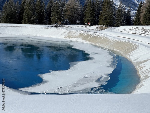 Beautiful winter atmosphere on storage lake Valos or reservoir lake Valos (Speichersee Valos) above the tourist resorts of Valbella and Lenzerheide in the Swiss Alps - Canton of Grisons, Switzerland photo