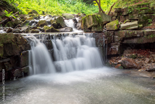 Water cascade on a forest stream. Long exposure waterfall. 