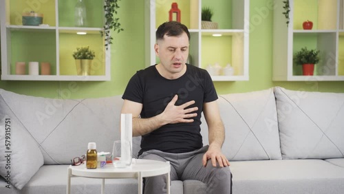 Man with shortness of breath and chest tightness.
The man who has chest tightness and shortness of breath at home is suffocating and suffering.
 photo