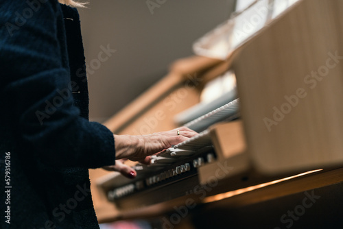 A musician playing a digital organ with three manuals © Janisphoto
