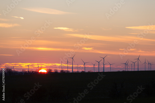 Wind turbines generate energy power electricity during the evening. Sunset, Silhouettes, wind turbines, clean energy