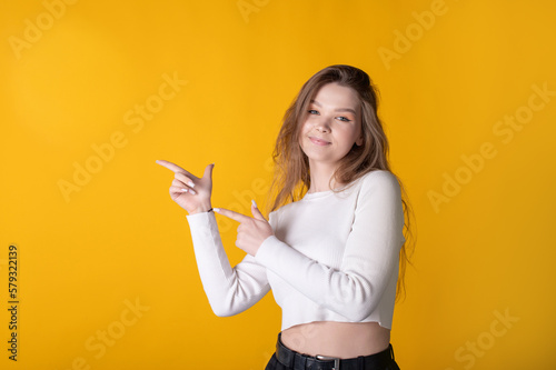 Photo portrait of a female student pointing her finger at the blank space of your product