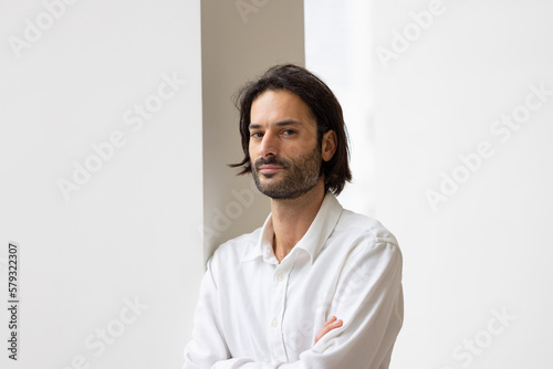 portrait d'un jeune homme de 30 ans souriant qui regarde la caméra. Il est debout dans son bureau. Homme d'affaires ou employé de bureau.