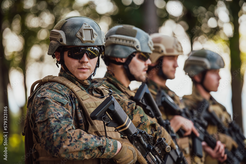 Soldier fighters standing together with guns. Group portrait of US army elite members, private military company servicemen, anti terrorist squad