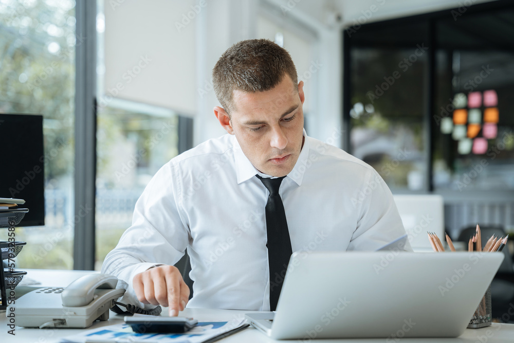 Business man using digital tablet analyzes business data, busy working on laptop computer with smart phone and business report on office desk, business strategy analysis concept. Business man using digital tablet analyzes business data, busy working on laptop computer with smart phone and business report on office desk, business strategy analysis concept.