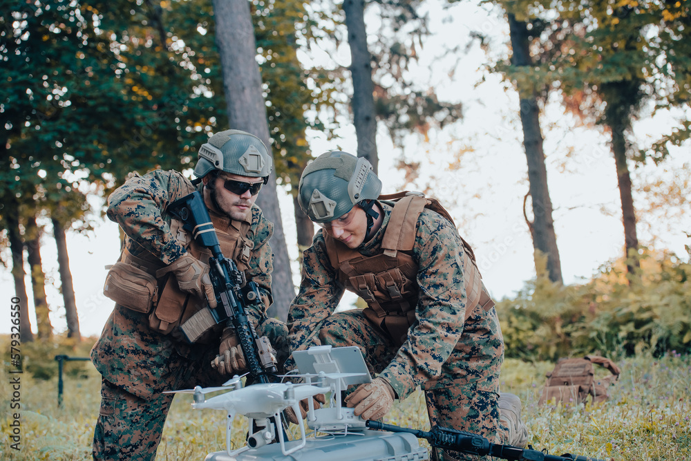 Fototapeta premium Modern Warfare Soldiers Squad are Using Drone for Scouting and Surveillance During Military Operation in the Forest.