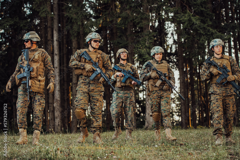 Soldier fighters standing together with guns. Group portrait of US army elite members, private military company servicemen, anti terrorist squad