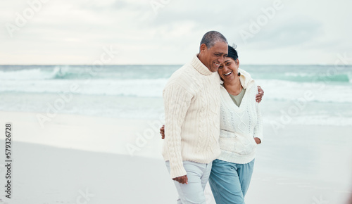 Senior couple  hug and beach walk together with funny moment  comic memory or conversation by sea. Happy retirement  ocean and outdoor embrace with love  bond or romance for laugh by waves on holiday