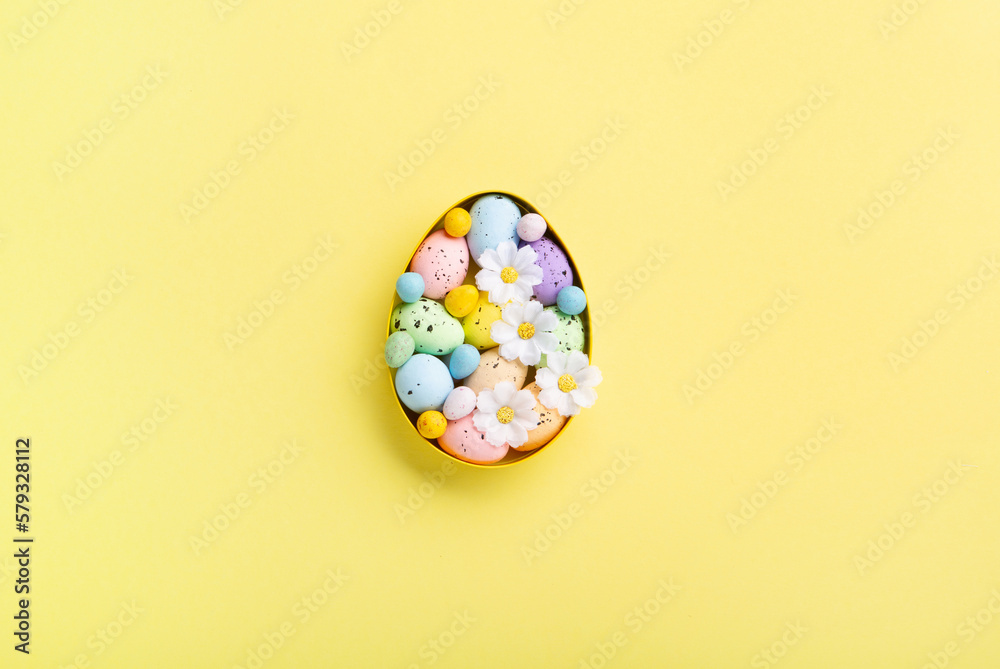 Easter Eggs with Sweets and Spring Flowers on Yellow Background Easter Eggs with Sweets and Spring Flowers on Yellow Background