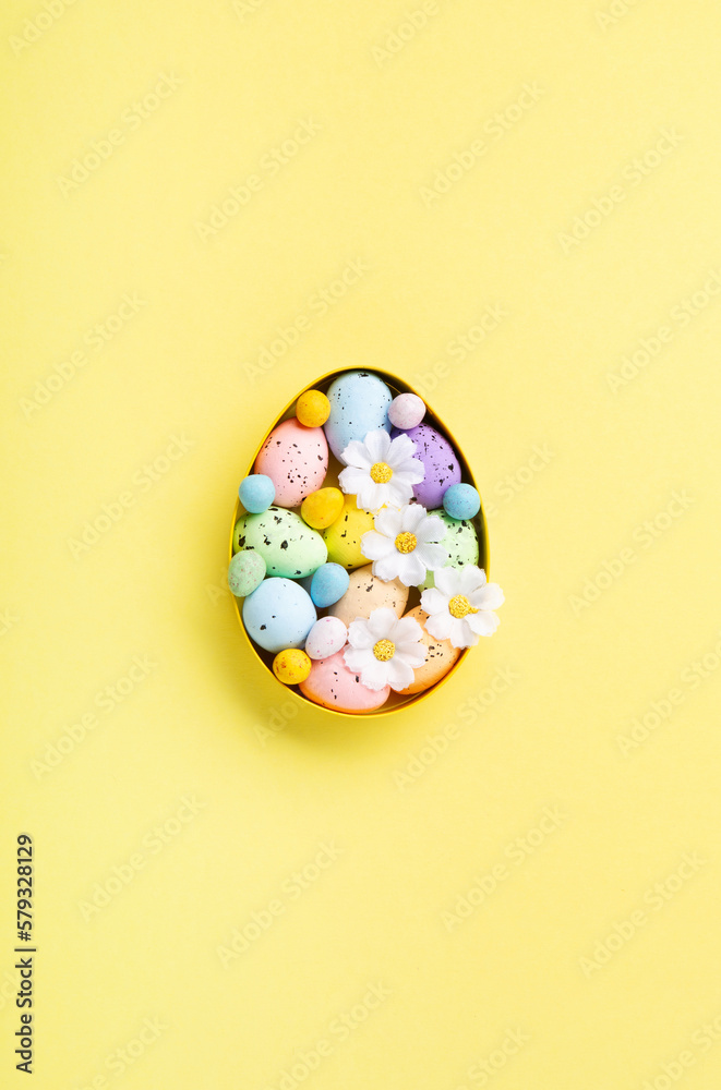 Easter Eggs with Sweets and Spring Flowers on Yellow Background