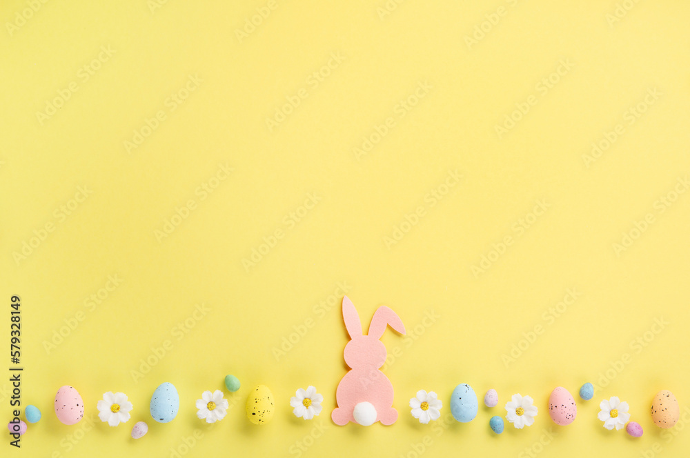 Easter Eggs with Sweets and Spring Flowers on Yellow Background