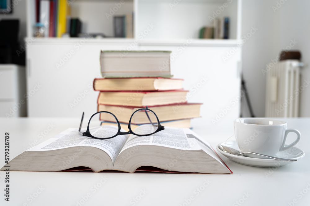 Stacks of books on a table, with a cup and glasses beside them. Study and culture.
Stacks of books on a table, with a cup and glasses beside them. Study and culture.