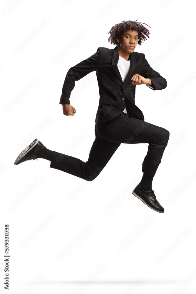 Full length shot of a young african american man in a black suit jumping Full length shot of a young african american man in a black suit jumping