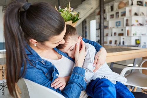 Caring mother comforts her sad son photo