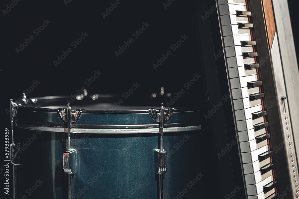 Drum and musical keys on a black background, close up.