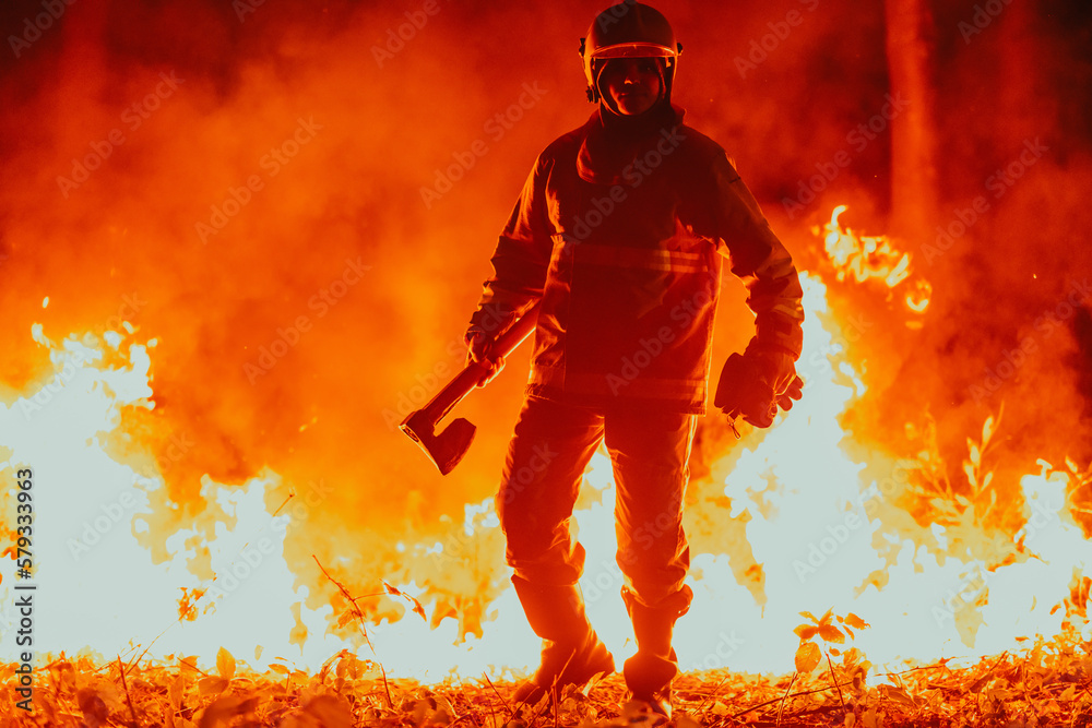 Firefighter at job. Firefighter in dangerous forest areas surrounded by strong fire. Concept of the work of the fire service Firefighter at job. Firefighter in dangerous forest areas surrounded by strong fire. Concept of the work of the fire service