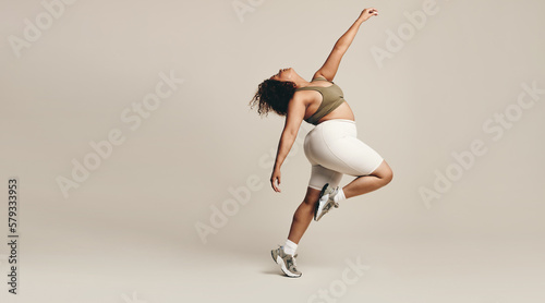 Fototapeta Naklejka Na Ścianę i Meble -  Dance and expression: Woman moving her body in a studio