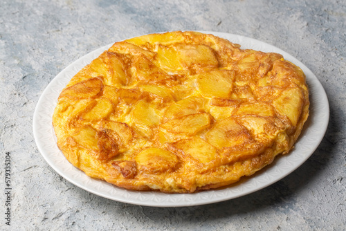 Spanish omelette with potatoes, typical spanish cuisine on gray concrete floor. Tortilla Espanola. Turkish name; Yumurtali patates