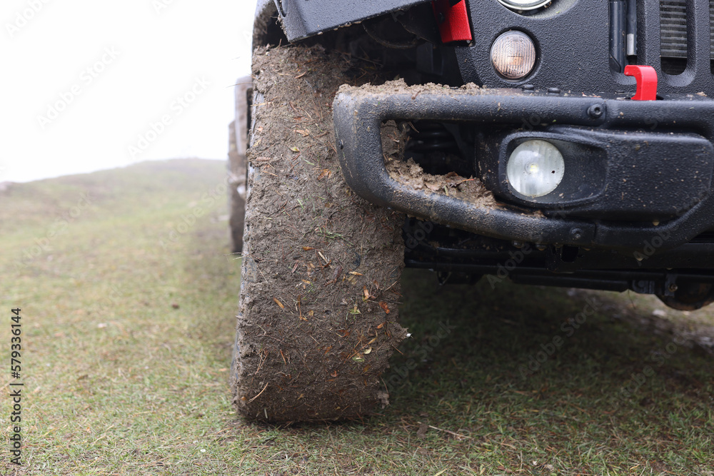 Close up of suv car with dirty wheels in field. Close up of suv car with dirty wheels in field.