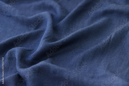 Wavy blue textile as background. Blue unicolor fabric close up.