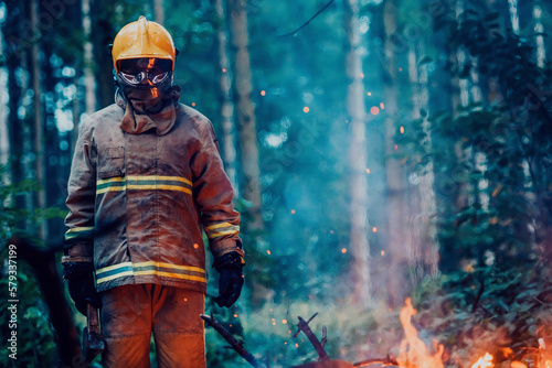 Firefighter at job. Firefighter in dangerous forest areas surrounded by strong fire. Concept of the work of the fire service