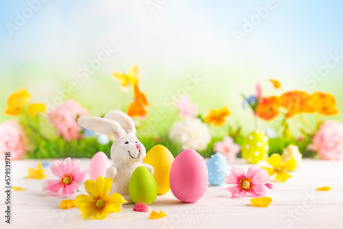 Happy Easter greeting card. Easter eggs  bunny  and spring flowers on table for decoration home for Easter.