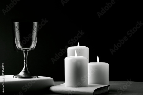 Fantastic metal chalice with candles about book  text space  photograph in Black and White