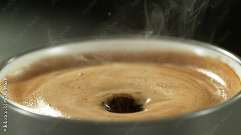 Super slow motion of falling drop into coffee with camera motion. Filmed on high speed cinema camera, 1000fps placed on high speed cine bot. Speed ramp effect.