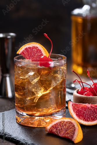 Old fashioned cocktail with cherrry and orange photo