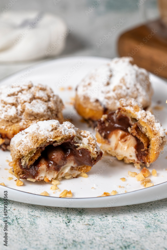 Freshly baked cream puffs. Eclair cake with cream and chocolate filling. Close up Freshly baked cream puffs. Eclair cake with cream and chocolate filling. Close up