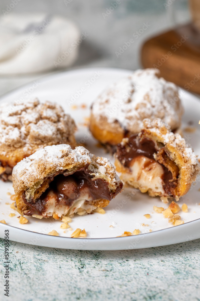 Freshly baked cream puffs. Eclair cake with cream and chocolate filling. Close up