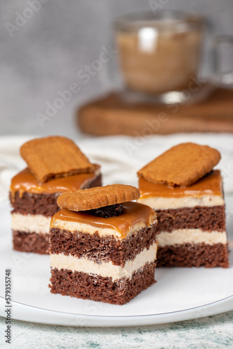 Small dessert cakes. Caramel petit four on a white plates in dark background. Biscuit french petit four cake. Close up