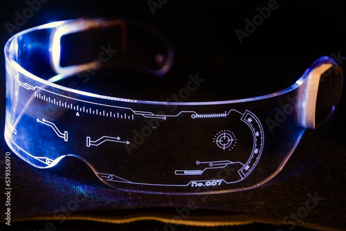 Futuristic glasses with drawings glow in blue on a black background