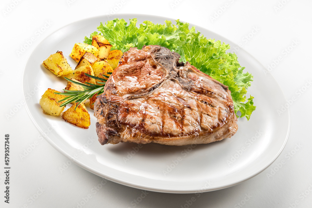 Grilled t-bone chop of pork with salad and potatoes