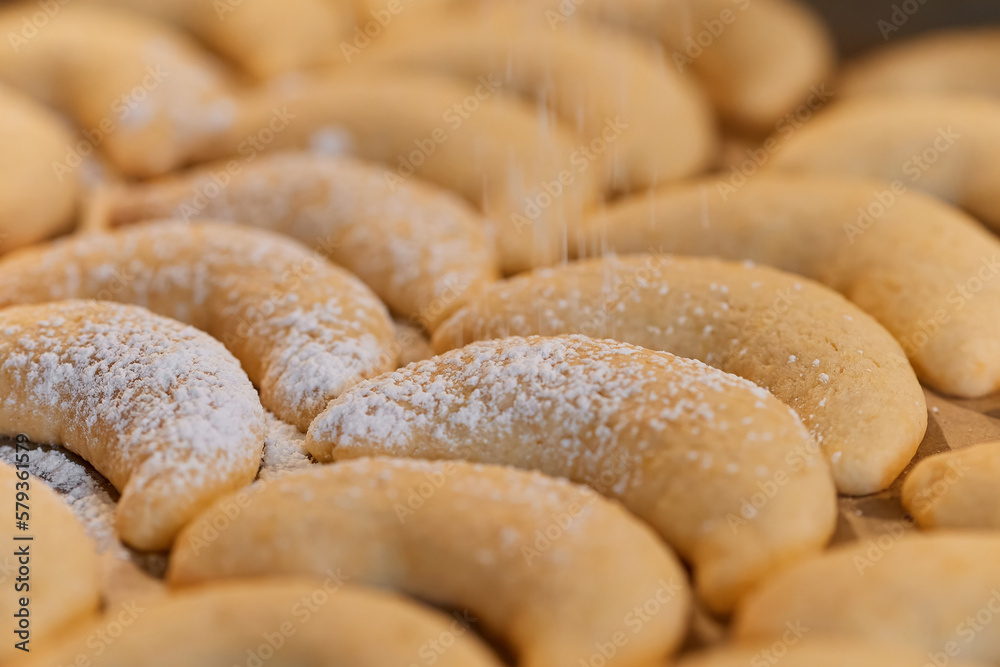 close up off vanilla crescents beeing dusted with powdered sugar