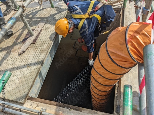 Fototapet Worker install settler for oil on oil sparator pit with confine space