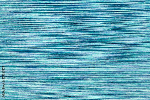 Sky blue yarn threads stretched on a loom abstract background. Turquois knitting yarn stings textured backdrop